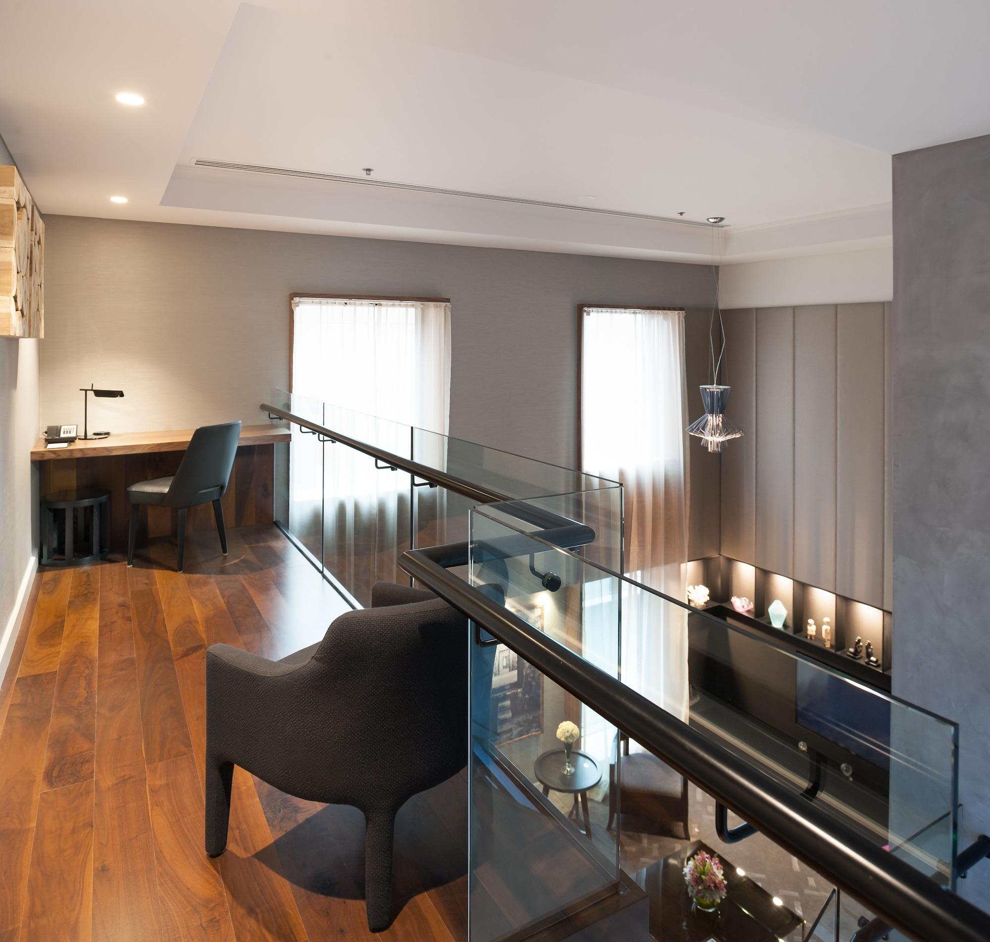 Stamford Plaza Melbourne Hotel Exterior foto The photo shows a modern interior space, featuring a second-floor balcony overlooking a lower level. The decor is stylish and minimalistic, with a combination of wooden flooring and neutral-colored walls. 

On the upper level, there is a small desk a