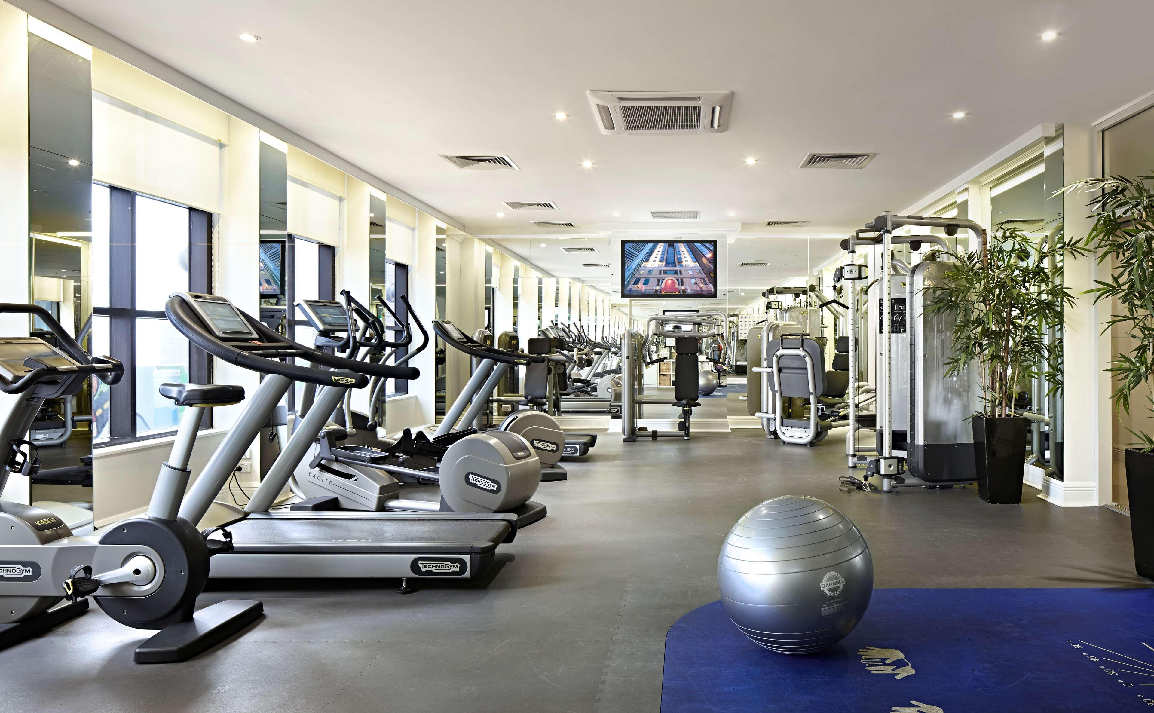 Stamford Plaza Melbourne Hotel Exterior foto The photo shows a modern gym or fitness center. There are several exercise machines, including treadmills and elliptical trainers, positioned near large windows that allow natural light to flood the space. A television is mounted on the wall, likely 