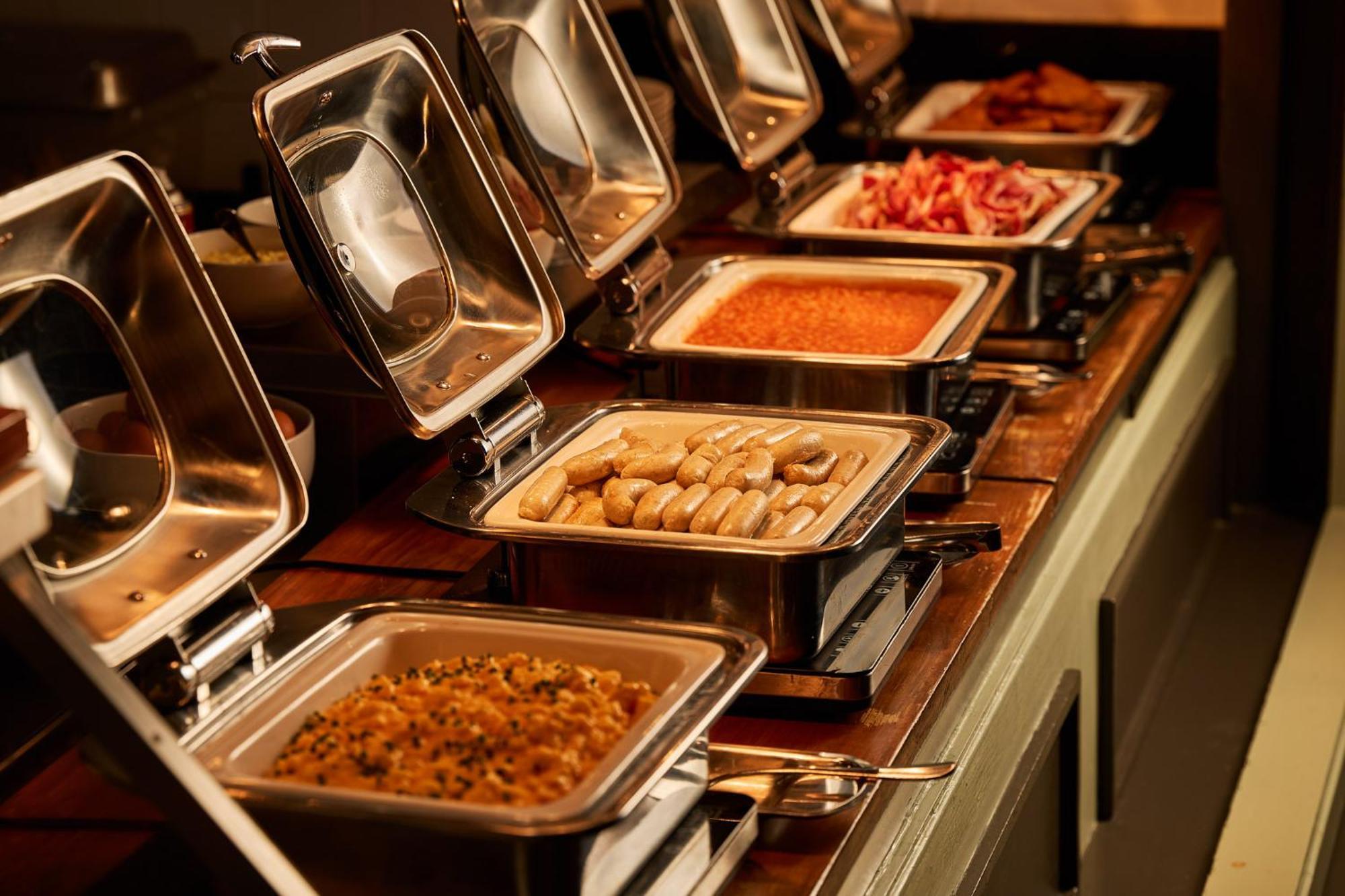 Stamford Plaza Melbourne Hotel Exterior foto The photo depicts a buffet setup featuring multiple food trays in stainless steel chafing dishes. Each dish is opened to display different types of food. The dishes contain a variety of items, which might include a mix of proteins, vegetables, or sta