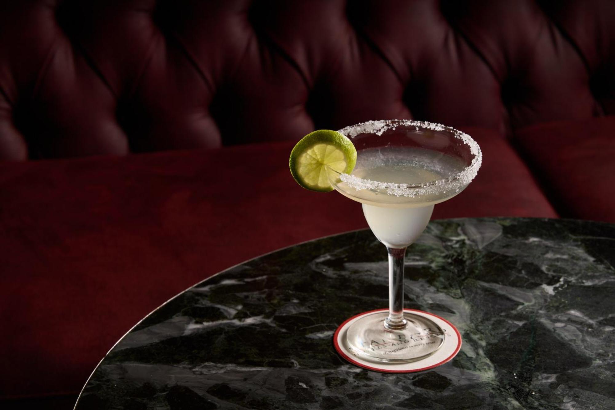 Stamford Plaza Melbourne Hotel Exterior foto The photo shows a beautifully presented margarita cocktail served in a classic margarita glass. The drink is clear with a salt rim around the edge, and adorned with a slice of lime. The glass is placed on a dark green marble table, contrasting with a