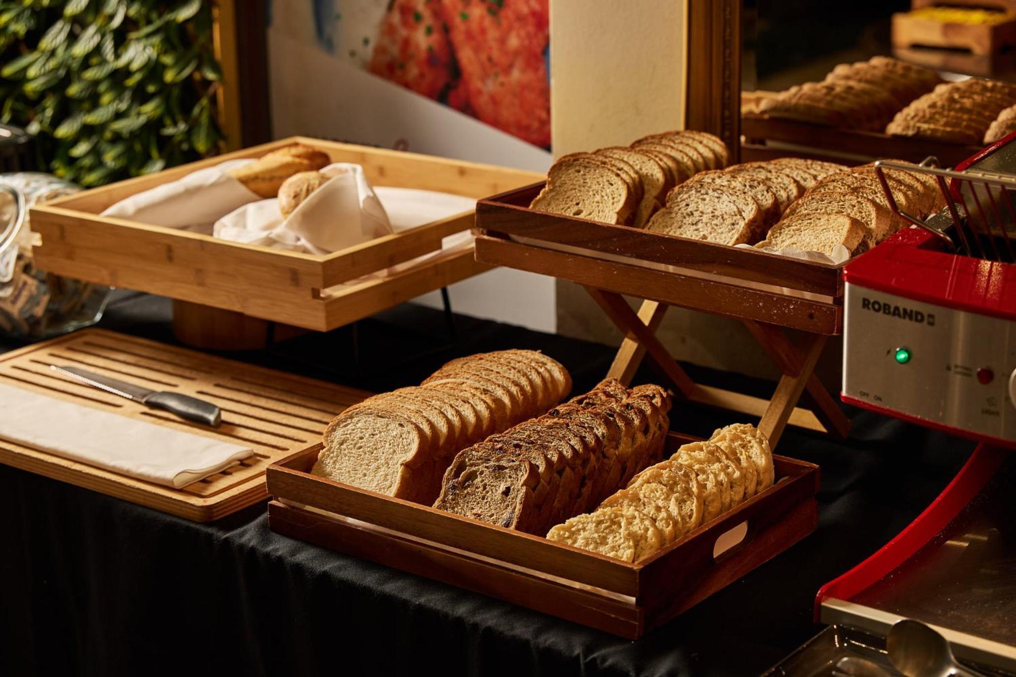Stamford Plaza Melbourne Hotel Exterior foto The photo shows a display of various types of bread arranged on wooden trays. There are several stacks of sliced bread, including light and dark varieties. One tray appears to hold a selection of whole grain or multigrain bread, while another feature