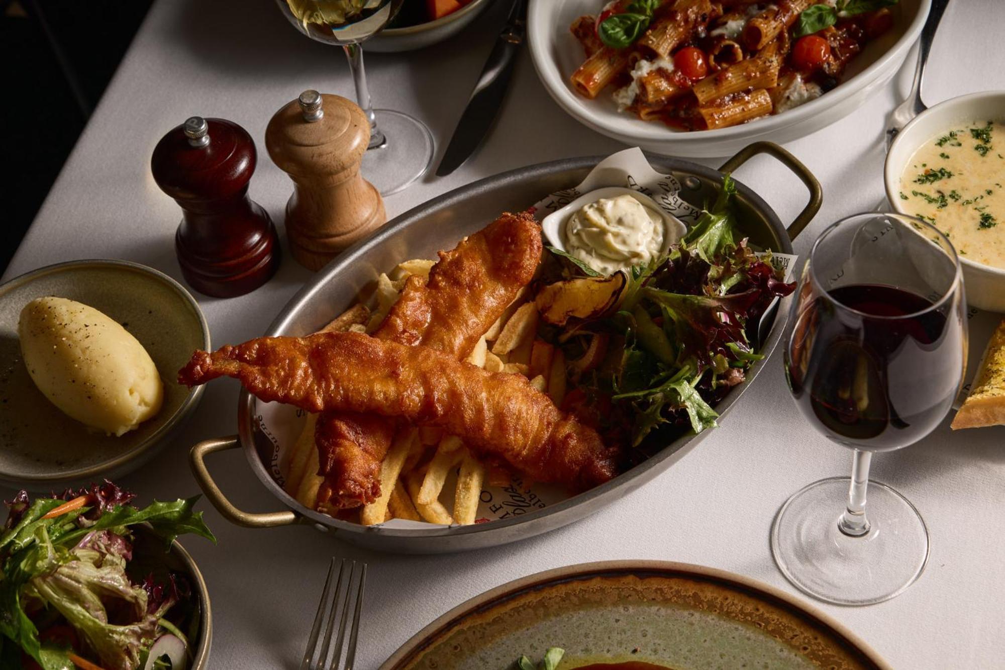 Stamford Plaza Melbourne Hotel Exterior foto The photo showcases a beautifully arranged meal. In the foreground, there are two pieces of golden-battered fish served with crispy fries. Accompanying the fish is a small dollop of creamy sauce and a side salad, which has a mix of greens. Surroundin