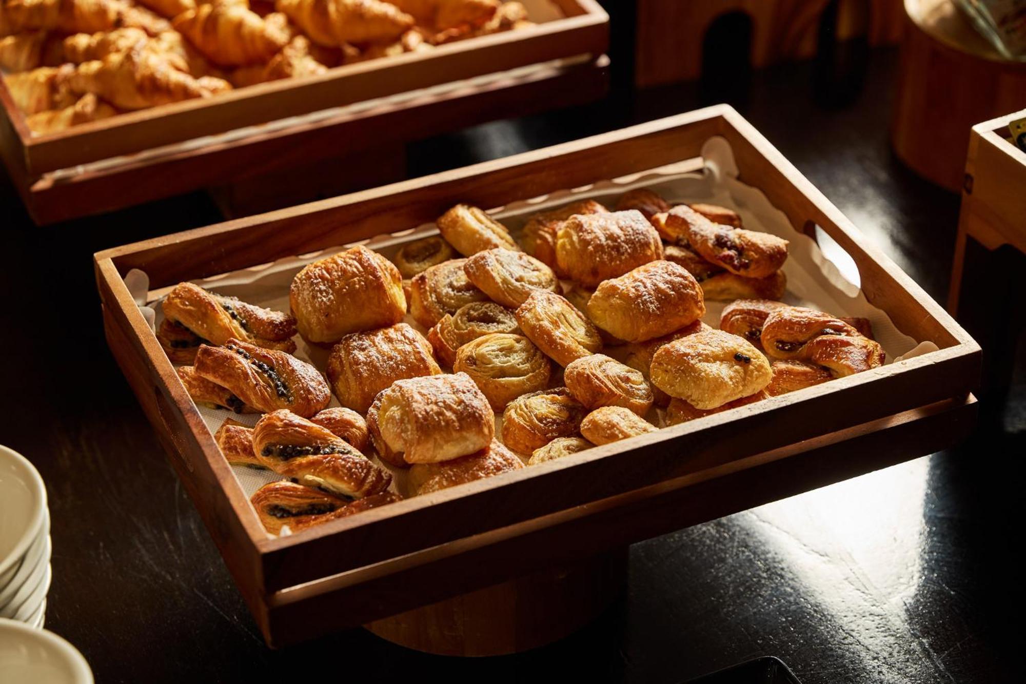 Stamford Plaza Melbourne Hotel Exterior foto The photo shows a wooden tray filled with an assortment of baked goods. There are various types of pastries, including small, flaky items that appear to be puff pastries, and possibly some filled with chocolate or fruit. The pastries are golden brown