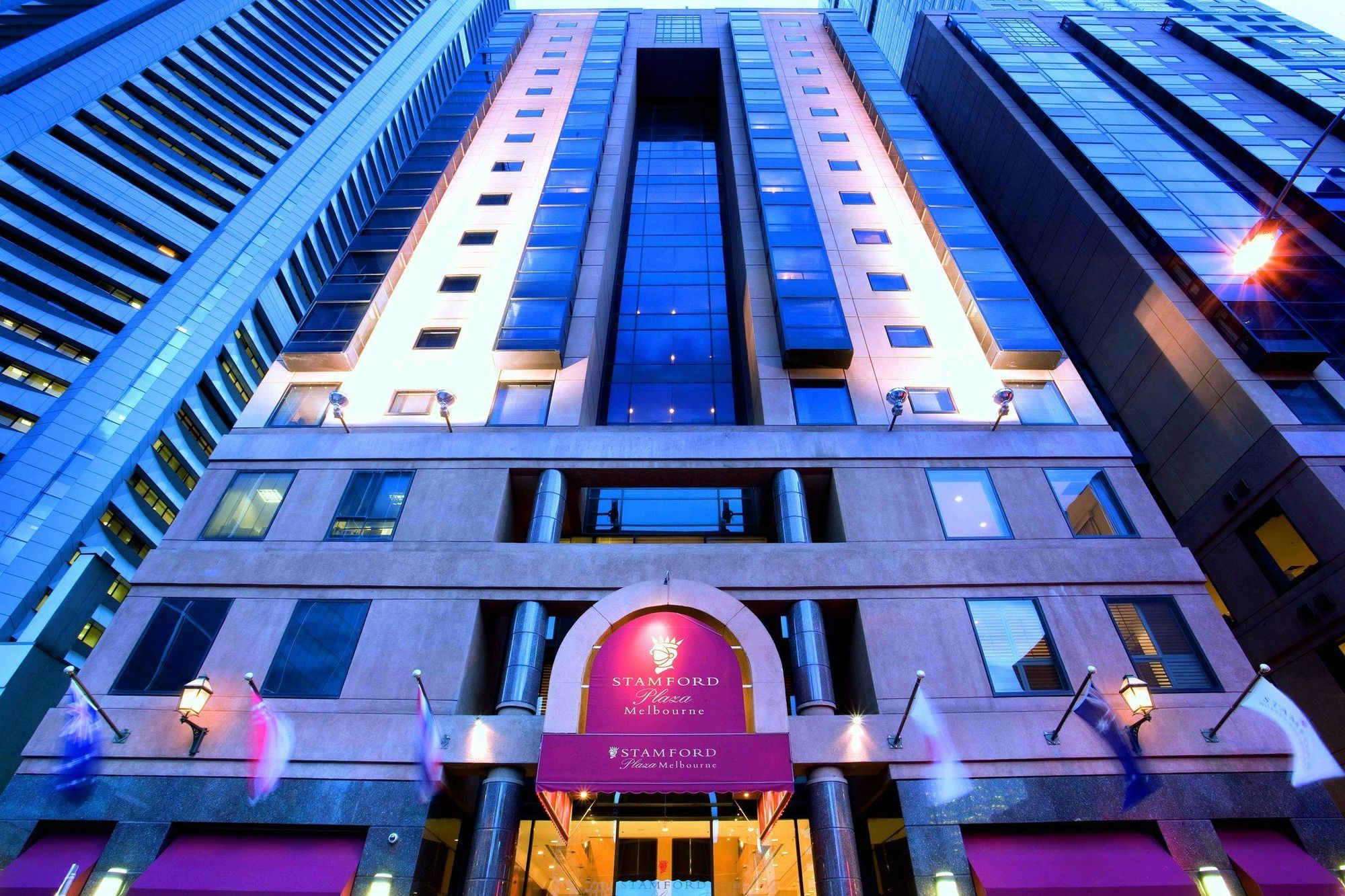 Stamford Plaza Melbourne Hotel Exterior foto The photo shows the exterior of a hotel, likely a luxury or high-end establishment. The building features a modern architectural design with a combination of glass and stone. The entrance is marked by a prominent sign, and the facade is illuminated, 